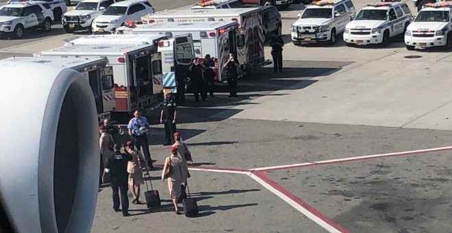 Ambulancias situadas en la pista de aterrizaje, al lado del avión puesto en cuarentena en el aeropuerto JFK de Nueva York. /REUTERS