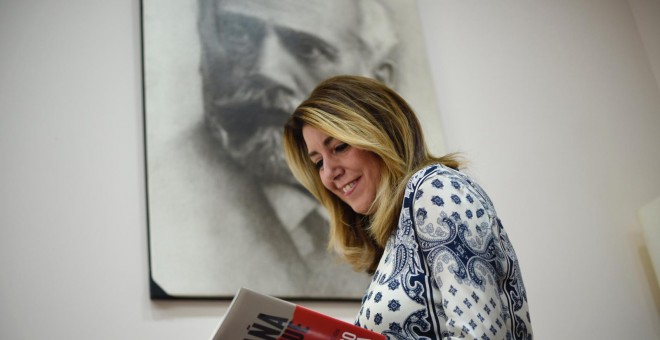 Susana Díaz lee el libro de Alfonso Guerra, delante de un retrato de Pablo Iglesias, fundador del PSOE