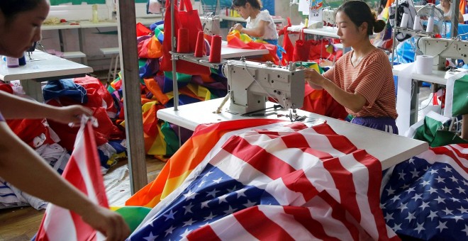 Un trabajador fabrica banderas nacionales de los Estados Unidos en la fábrica de banderas Jiahao en Fuyang, provincia de Anhui, China. | Reuters