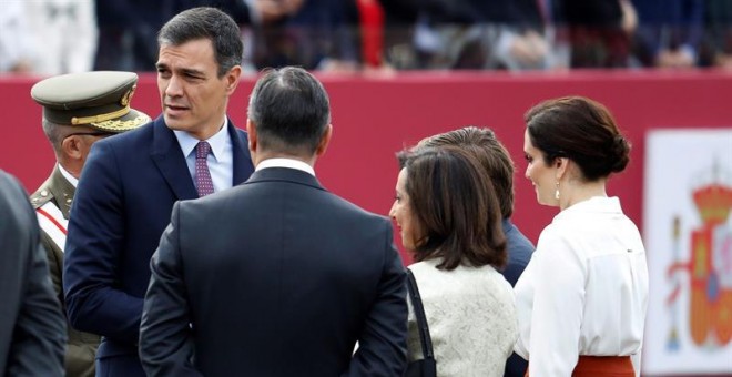 El presidente del gobierno Pedro Sánchez (i), en el madrileño Paseo de la Castellana, lugar en el que se celebra el desfile de la Fiesta Nacional, esta mañana en Madrid.- EFE/Ballesteros