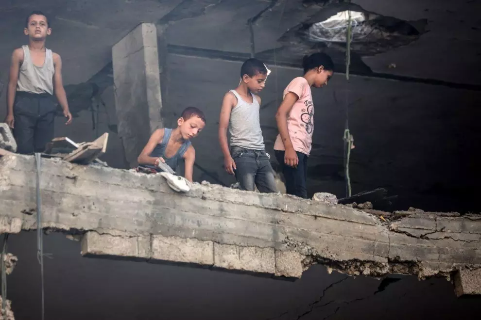 Varios niños palestinos miran los daños tras un ataque israelí en un campo de refugiados, a 13 de julio de 2024. — Majdi Fathi / AFP