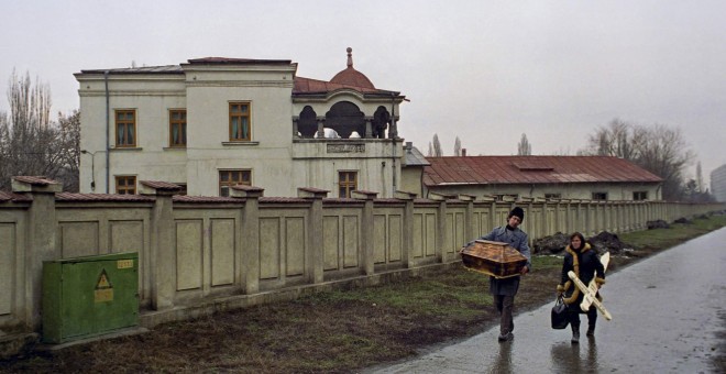 Unos padres rumanos llevan un pequeño ataúd donde va el cuerpo de bebé, muerto por el sida en un hospital de Bucarest (6 de febrero de 1990). REUTERS / Radu Sigheti