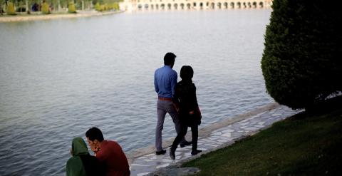 Varias parejas caminan y se sientan en la orilla del río Zayandeh, en la histórica ciudad de Isfahan, Irán. -AFP PHOTO / BEHROUZ MEHRI