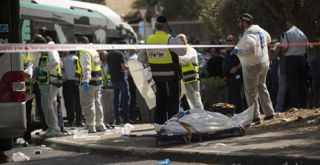 Los servicios de emergencia israelíes trabajan en el lugar del suceso después de que dos personas atacaran con un arma de fuego y un cuchillo un autobús en el barrio de Armon Hanatziv, Jerusalén. - EFE