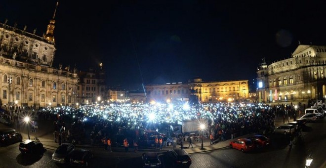 Seguidores del movimiento islamófobo Pegida encienden las linternas de sus teléfonos celulares durante una manifestación en la plaza Theaterplatz de Dresde (Alemania)./ EFE