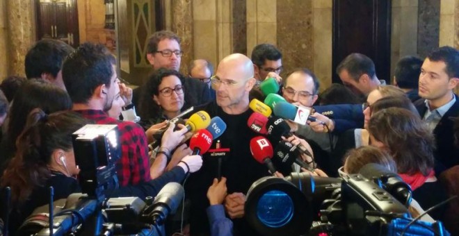 El cabeza de lista de Junts pel Sí (JxSí), Raül Romeva, rodeado de periodistas en los pasillos del Parlament. E.P.