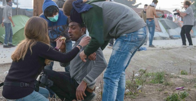 Un grupo de voluntarios atiende a uno de los heridos por las cargas de los agentes. / PABLO GABANDÉ