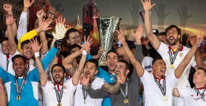 Jugadores y cuerpo técnico del Sevilla celebran con el trofeo de la Liga Europa. /EFE