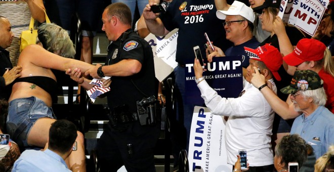 Un policía trata de reducir a una manifestante en el mitin de Trump en Albuquerque./ REUTERS