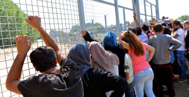 Un grupo de refugiados espera para cruzar la frontera entre Serbia y Hungría en un campamento situado cerca del puesto de Horgos, en Serbia hoy.-EFE/Edvard Molnar