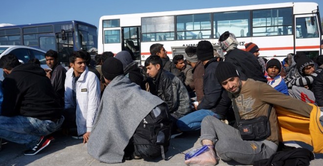 Migrantes y refugiados esperan a ser recogidos en autobuses para entrar en el 'hotspot' de Moria, en Grecia. - AFP