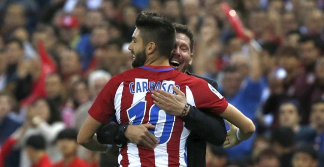 El entrenador del Atlético de Madrid Diego Pablo Simeone (d) felicita al delantero belga Yannick Ferreira Carrasco (i), tras marcar su tercer gol ante el Granada, durante el partido de la octava jornada de Liga en Primera División disputado esta tarde en