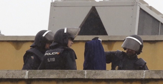 Efectivos de la Policía Nacional permanecen en la azotea del Centro de Internamiento de Extranjeros (CIE) de Aluche, en Madrid, donde anoche se encerraron unos cuarenta inmigrantes. EFE/Paco Campos