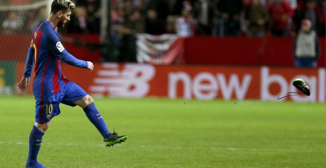 El delantero argentino del F. C. Barcelona, Leo Messi, golpea una de sus botas tras recibir una falta durante el encuentro  que han disputado frente al Sevilla en el estadio Sánchez Pizjuán de la capital andaluza. EFE/José Manuel Vidal.