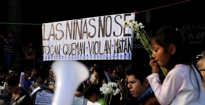 People take part in a protest to demand justice for the victims of a fire at the Virgen de Asuncion children's shelter, in front of the National Palace in Guatemala City, Guatemala, March 11, 2017. REUTERS/Saul Martinez