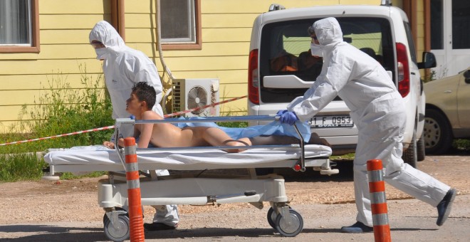 Médicos turcos con trajes de protección trasladan a un herido en el ataque químico a Idlib (Siria). /REUTERS