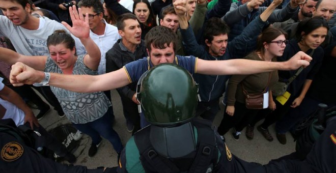 Un joven se enfrenta a un agente de la Guardia Civil. | REUTERS