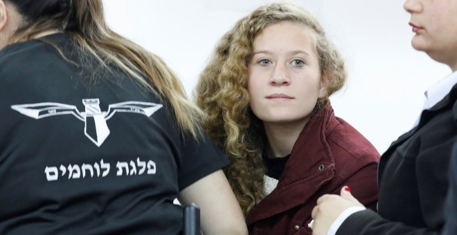 La adolescente palestina  Ahed Tamimi, es escoltada por agentes de la policía israelí hacia un juzgado en la localidad de Betunia (Palestina). EFE/ Abir Sultan