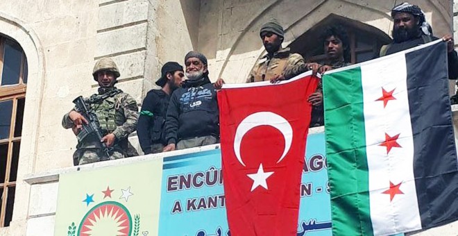 Soldados turcos y milicianos del 'Ejército Libre de Siria' armado por Ankara cuelgan las banderas de Turquía y Siria en el centro de la ciudad kurda de Afrín. EFE/EPA/DOGAN NEWS AGENCY