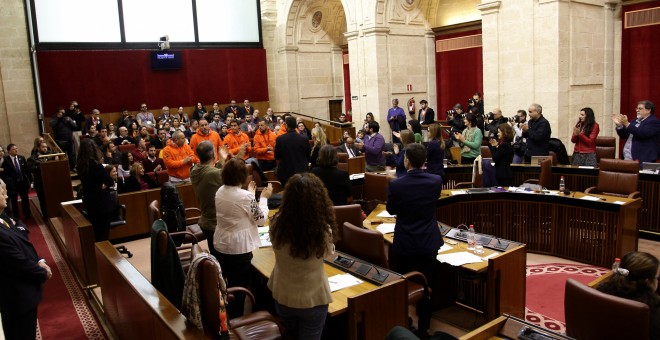 El Pleno de Parlamento puesto en pié aplaude a los compañeros de los bomberos de la ONG Proemaid.