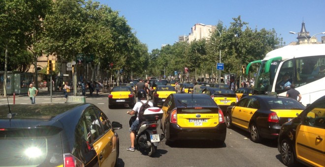 Taxistes en marxa lenta bloquegen els carrils centrals de la Gran Via de Barcelona, a l'alçada de Plaça Universitat. / LC.