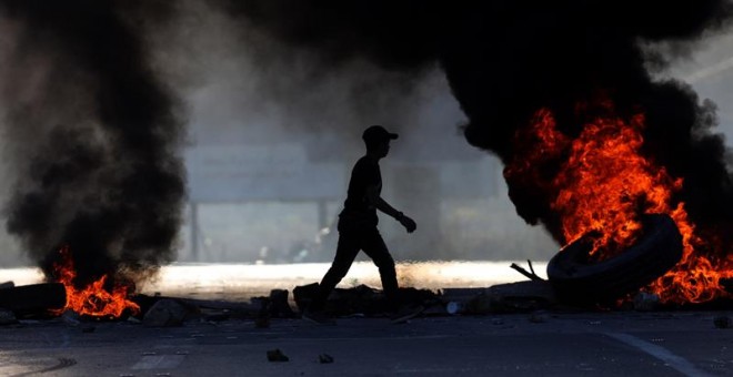 Palestinos participan durante una protesta en el cruce de Huwara, cerca de Nablus, Cijsordania, hoy, 14 de diciembre de 2018. Cinco palestinos resultaron heridos durante las protestas, según informaciones. EFE/ Alaa Badarneh