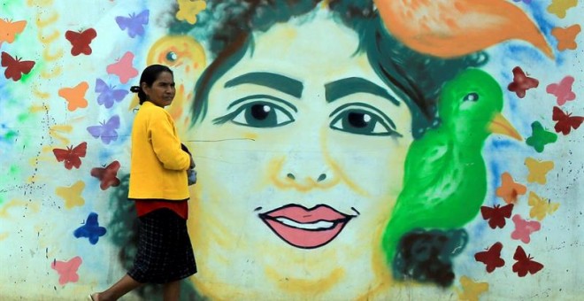 Una mujer camina frente a un mural pintado con el rostro de la ambientalista hondureña asesinada el 2 de marzo de 2016, Berta Cáceres, este jueves en la ciudad de La Esperanza (Honduras). Grupos defensores de los recursos naturales y familiares de Berta C