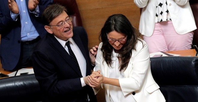 12/06/2019.- El candidato a la reelección como president de la Generalitat, Ximo Puig, y la vicepresidenta en funciones, Mónica Oltra, se dan la mano tras su discurso de investidura en Les Corts Valencianes. EFE/Manuel Bruque