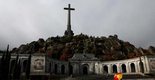 20/10/2019.- Una mujer sostiene un paraguas en el Valle de los Caídos, el mausoleo que contiene los restos del ex dictador Francisco Franco. / REUTERS (Susana Vera)