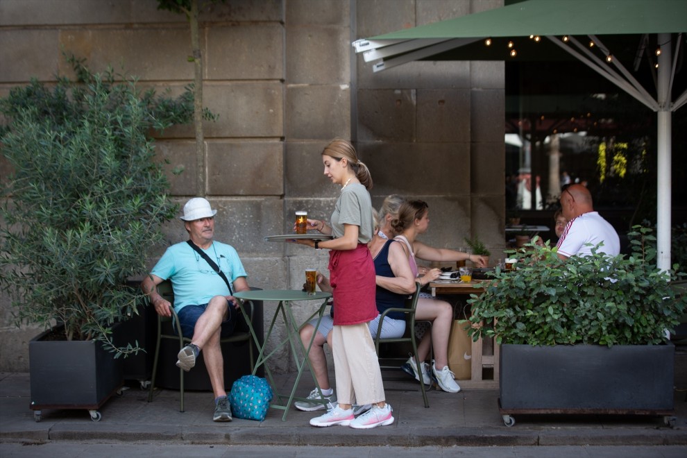 Una camarera sostiene una bandeja en la plaza Real de Barcelona, a 15 de junio de 2022, en Barcelona, Catalunya (España). Los empresarios del turismo y la hostelería han reiterado la ausencia de trabajadores en su sector