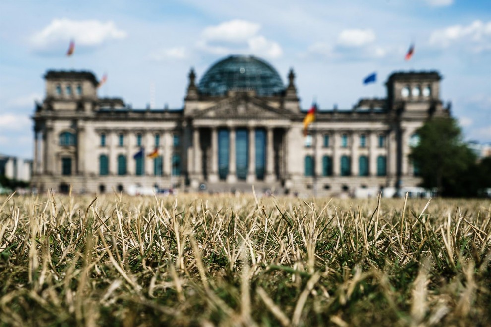 La hierba frente al edificio del Reichstag, la sede del Bundestag del Parlamento alemán, se seca durante las altas temperaturas, en el parque Lustgarten en Berlín, Alemania, el 04 de agosto de 2022. El Servicio Meteorológico Alemán (DWD) espera que la ola