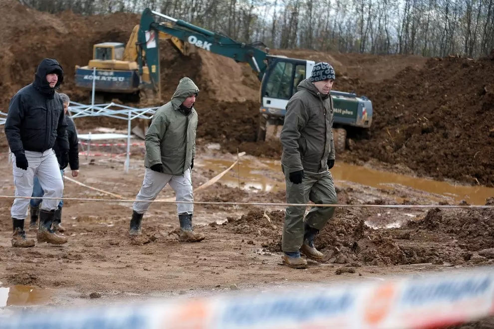 Expertos forenses, miembros de la Comisión Internacional de Personas Desaparecidas (ICMP) y trabajadores bosnios buscan mientras llueve restos humanos en Tomašica, en una imagen de archivo tomada en 2013