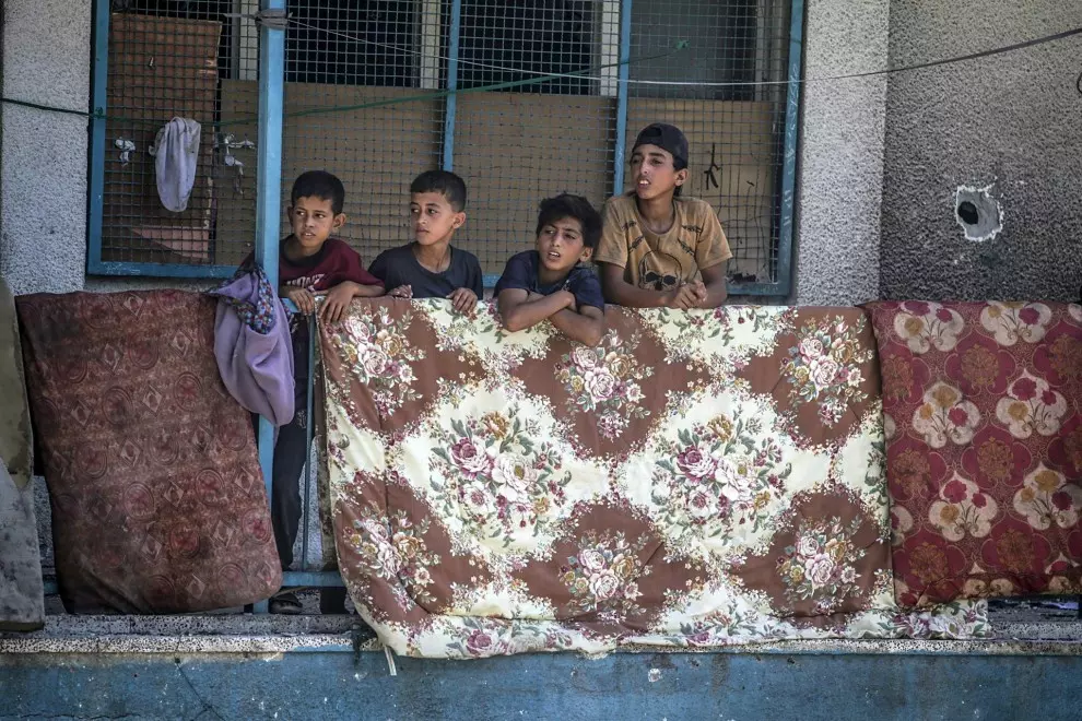 Niños palestinos desplazados en un balcón de la escuela de la UNRWA destruida por los bombardeos de Israel.