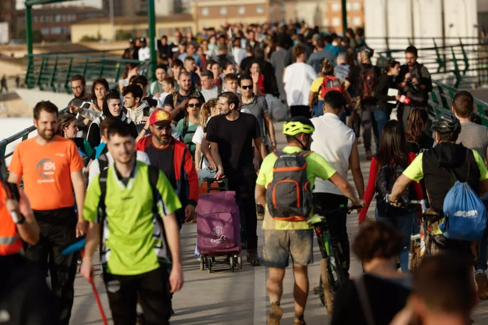 Cientos de personas cruzan la pasarela de Valencia hacia el barrio valenciano de La Torre, con alimentos y herramientas para ayudar al desescombro tras DANA, este jueves.