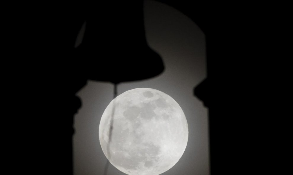 La superluna, tras el campanario de la iglesia de San Nicolás, en Cali (Colombia). AFP/LUIS ROBAYO