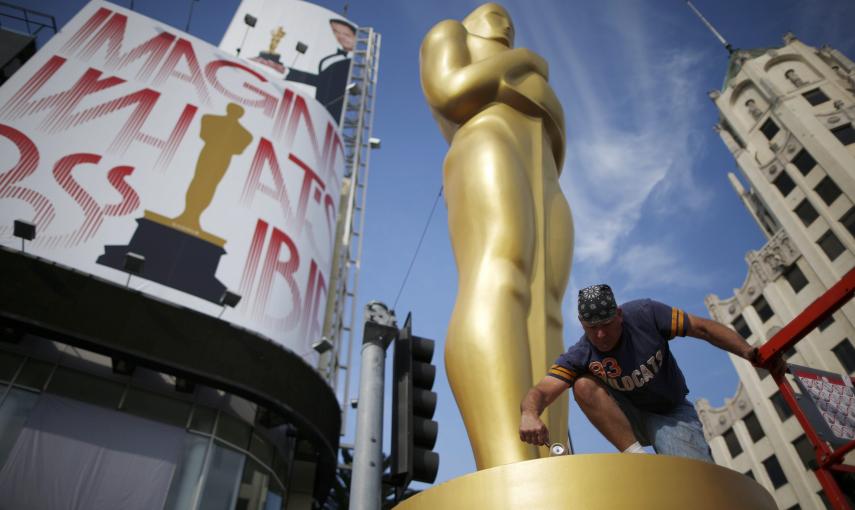 El decorador Rick Roberts pinta de dorado una de las estatuas del Oscar, junto al Dolby Theater donde se celebrará la ceremonia de entrega de los 87ª premios de la Academia de Hollywod. REUTERS/Lucy Nicholson