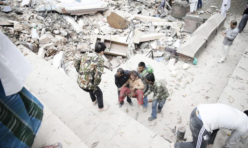 Varias personas sacan a una mujer de entre los escombros de un edificio destruido por el terremoto de Nepal, en Katmandú.-EFE / EPA / NARENDRA SHRESTHA