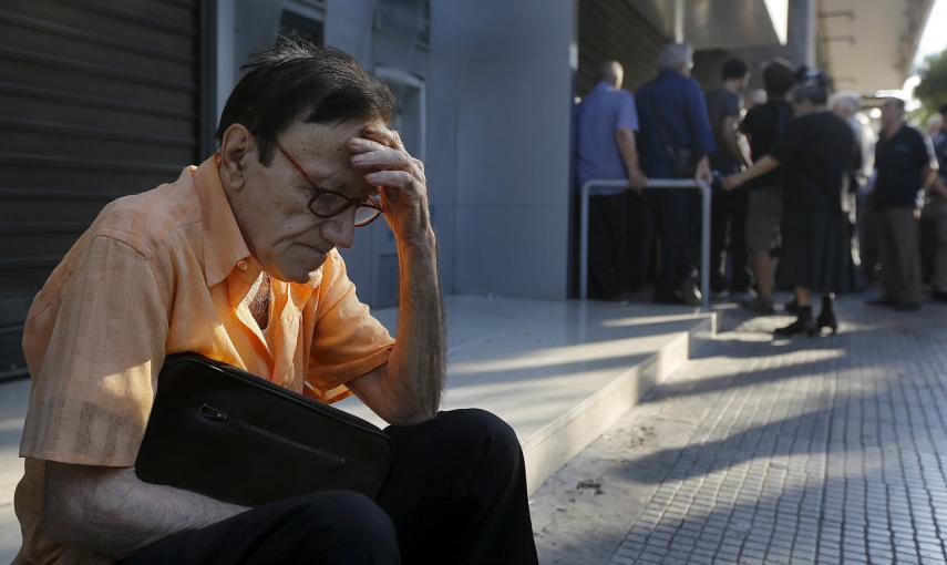 Giorgos, un jubilado de 77 años de edad, de Atenas, espera en la puerta de una sucursal del Banco Nacional de Grecia mientras junto con docenas de otros pensionistas, con la esperanza de obtener sus pensiones tras decretarse el corralito. Cada griego pued