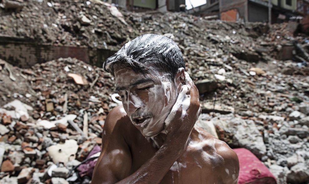 Un joven nepalí se lava la cabeza en Thamel, Katmandú (Nepal) hoy, 23 de julio de 2015. Tras los graves destrozos causados por el terremoto que asoló Nepal el pasado mes de abril los locales se enfrentan a dificultades diarias para acceder a los suministr