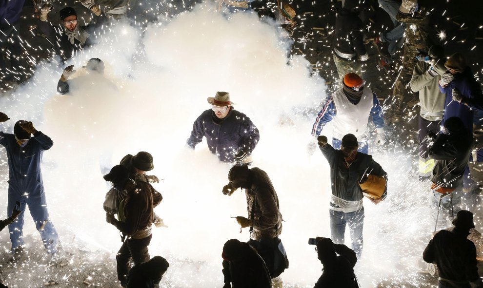 Participantes en la "guerra de carretillas" esta noche en las calles de Elche, durante la tradicional Nit del Albà. EFE / Manuel Lorenzo.