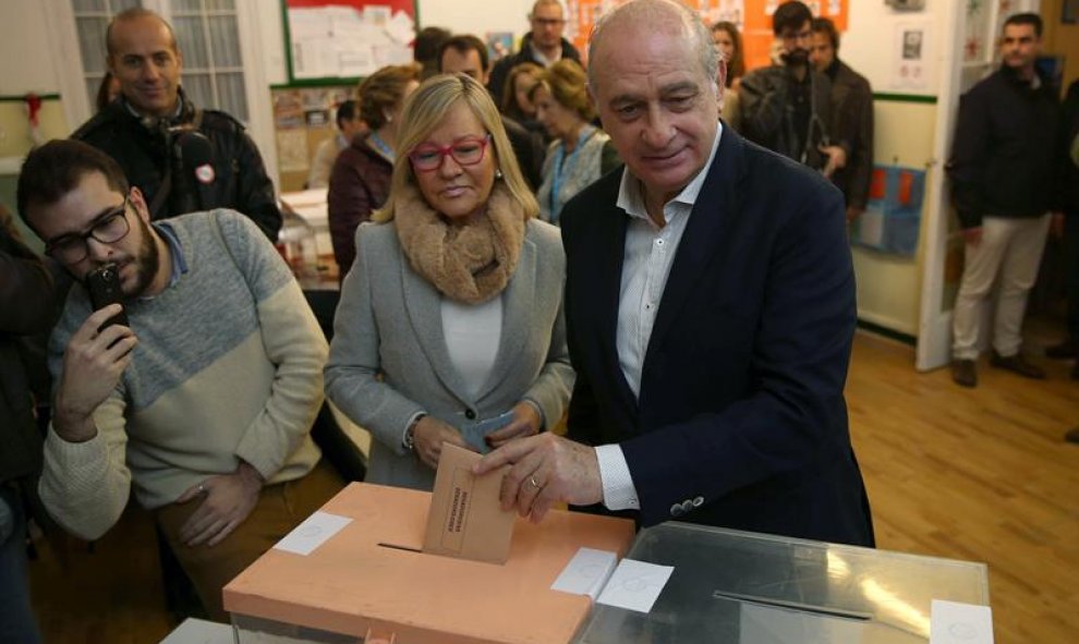 El ministro del Interior y cabeza de lista por el PPC, Jorge Fernández Díaz, acompañado de su esposa Asunción Carácoba, vota en la Escuela Augusta de Barcelona. EFE