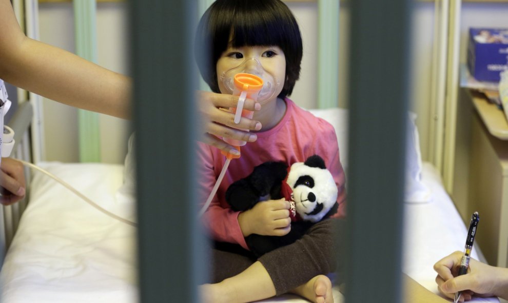 Una niña de dos años recibe es asistida en un hospital tres días después de que la capital china emitiese su segunda "alerta roja" por la contaminación del aire, en el Hospital de New Century International Children, en Beijing, China. REUTERS / Jason Lee