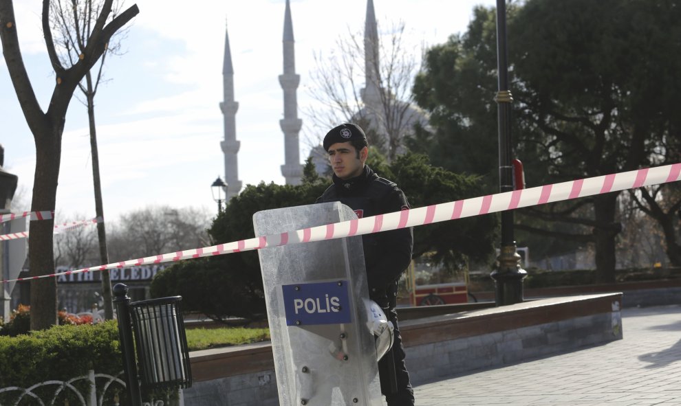 Un policia turco junto a la barrera de seguridad desplegada  cerca de la Mezquita Azul, en la plaza de Sultanahmet, la pricipal zona turística de Estambul, tras el atentado suicida que ha provocado al menos diez muertos y quince heridos. REUTERS/Kamal Asl