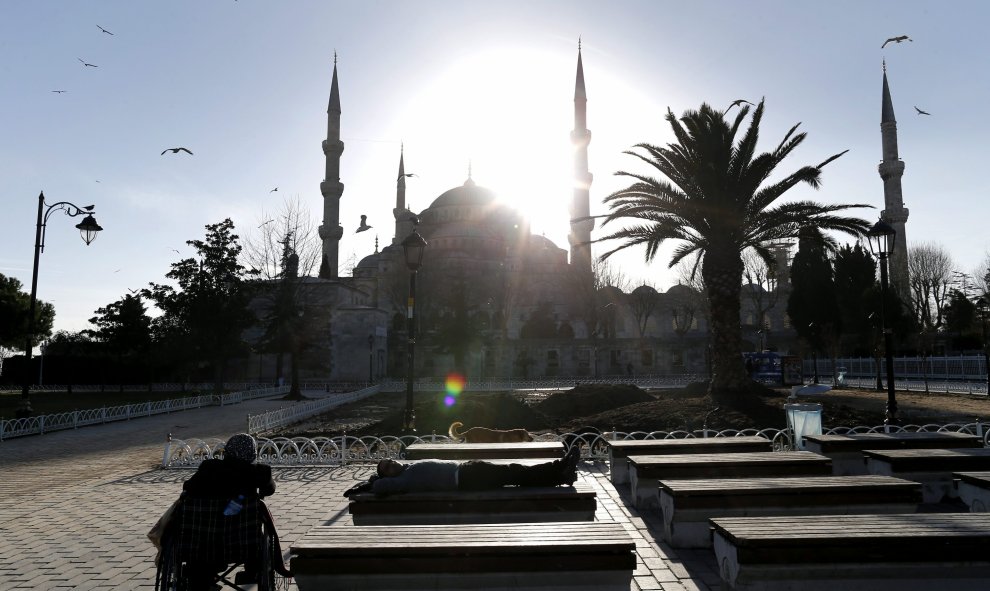 Varias personas descansan en unos bancos situados frente a la Mezquita Azul tras el atentado suicida perpetrado en el turístico distrito de Sultanahmet, en el centro de Estambul (Turquía). EFE/Sedat Suna