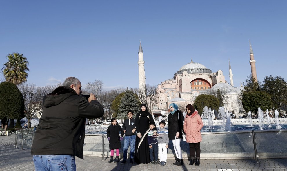 Una familia posa para una foto con Santa Sofía de fondo tras el atentado suicida perpetrado en el turístico distrito de Sultanahmet, en el centro de Estambul (Turquía). EFE/SEDAT SUNA