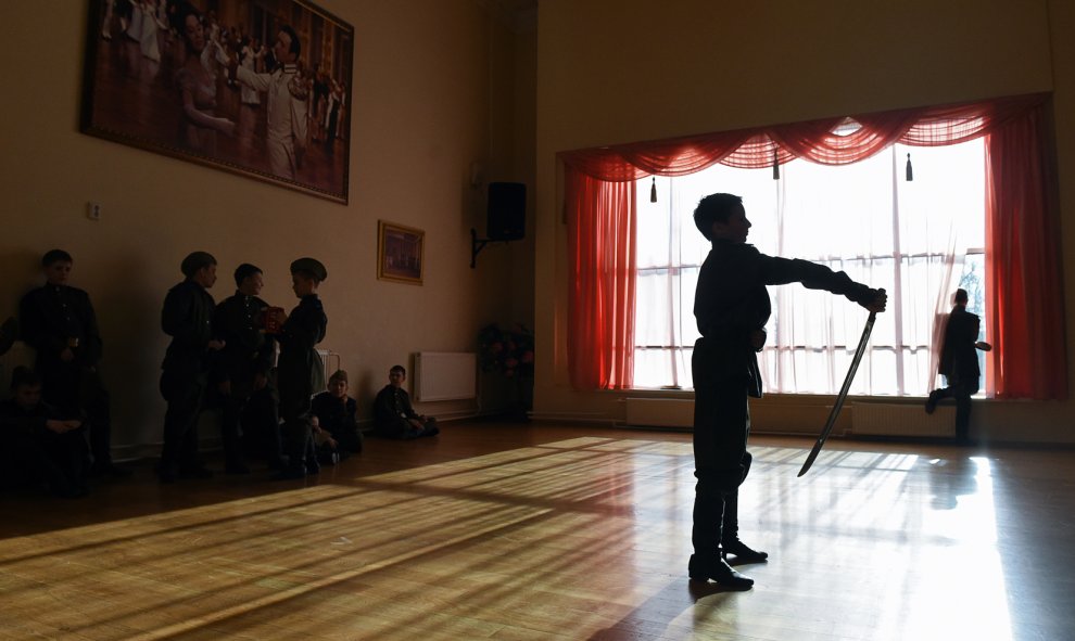 Un estudiante de la Escuela de Cadetes Presidencial de Moscú realiza una exhibición con un sable en el pasillo de la escuela. AFP PHOTO/VASILY MAXIMOV