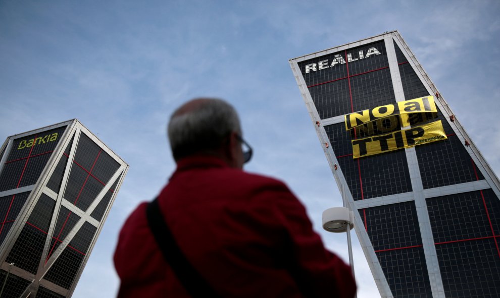 Un hombre oberva el cartel contra el TTIP colgado por activistas de Greenpeace. REUTERS/Andrea Comas