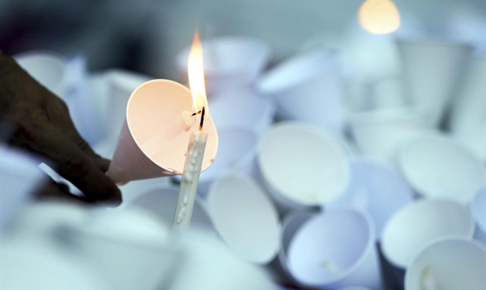 Un asistente enciende una vela durante una vigilia en la Alliance Française en Bangkok (Tailandia) en memoria de las víctimas de la masacre de Niza. EFE/Diego Azubel