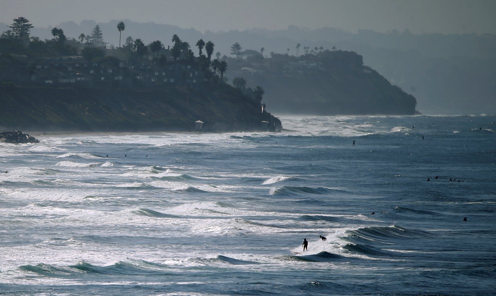 La gente disfruta de la playa y las olas en un día de otoño a lo largo de la costa en Carlsbad, California, USA. REUTERS / Mike Blake