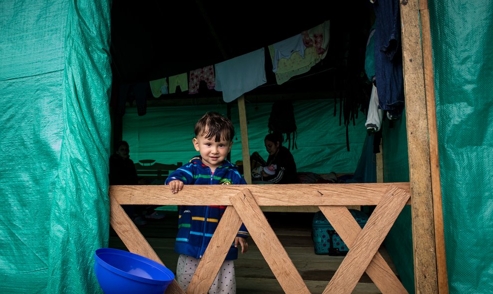 Un niño en una de las cabañas improvisadas por los guerrilleros de las FARC en el campamento de transicIón de La Fila, en Tolima.- JAIRO VARGAS